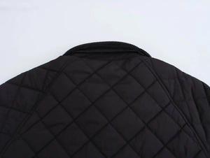 Detail of diamond quilted jacket with corduroy collar and premium stitching
