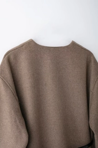 Detailed close-up of dark brown wool blend coat neckline and premium fabric texture