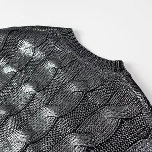 Close-up of silver metallic knit sweater with cable pattern and ribbed crew neckline