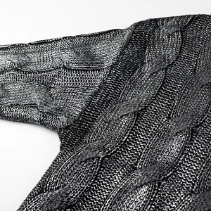 Close-up of metallic silver cable knit texture on a stylish chunky pullover sweater