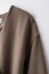 Close-up of brown wool coat collar with size label showing EUR S USA S MEX 26 details