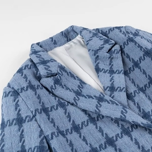 Close-up of blue tweed texture and houndstooth pattern on a street fashion jacket