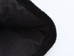 Close-up of black corduroy jacket fabric with smooth inner lining and neat stitching