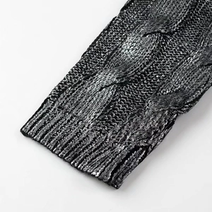 Close-up of cable knit sweater detail with metallic silver-black coating finish