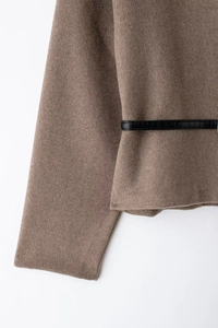 Close-up of brown wool jacket texture featuring a black crocodile-embossed waist belt