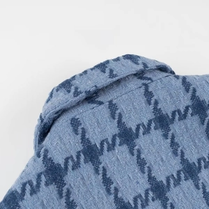 Macro view of blue tweed fabric texture with houndstooth pattern for stylish jacket