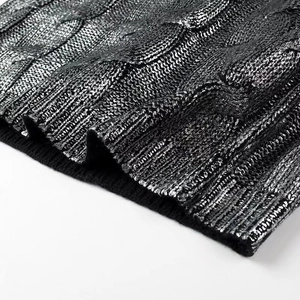 Detail of cable knit fabric with metallic silver coating and black ribbed hem finish