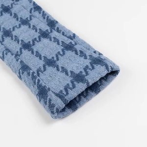 Close-up of the blue houndstooth tweed sleeve showing refined texture and stitching detail