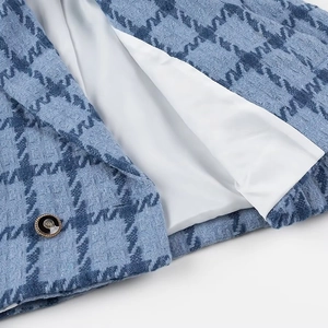 Detailed macro view of the blue and white tweed fabric texture and decorative button