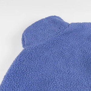 Detailed macro view of soft blue periwinkle sherpa fleece fabric texture with stitched hem