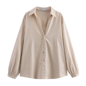Detail view of cotton linen shirt collar with button closure and puffed sleeve cuffs