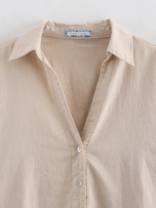 Detail of linen blend shirt showing V-neck collar, shell buttons, and brand label