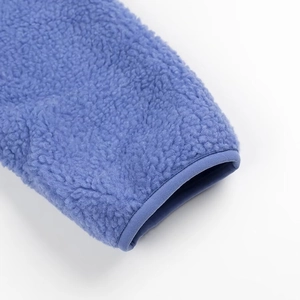 Detailed close-up of blue sherpa fleece fabric sleeve with elastic cuff stitching