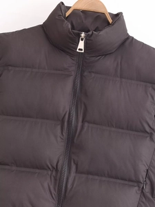Detail of a black quilted puffer vest showing the stand collar and metal zipper closure