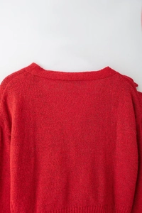 Dettaglio del maglione in maglia rossa con trama di alta qualità e design del colletto