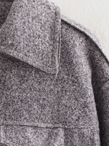 Close-up of mauve bouclé fabric texture and collar detail on a short zipper jacket