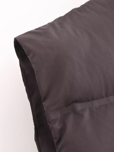 Detail of quilted seam and thick padding on the black puffer vest shoulder area