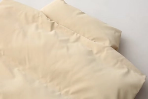 Detail of high-density cream beige bedding set with smooth matte texture and minimalist style