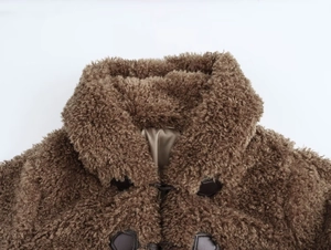 Close-up of faux fur coat collar and dark brown toggle buttons with smooth inner lining