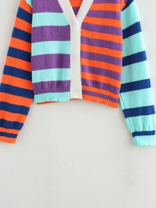 Detailed close-up of striped knit cardigan featuring V-neck and white buttons
