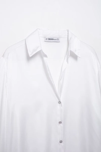 Gros plan détaillé du col d'une chemise en satin blanc avec texture de tissu haut de gamme