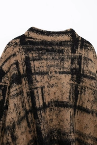 Detail of knit sweater neckline with brown plaid pattern and soft fuzzy texture