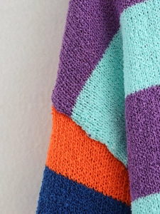 Close-up of multicolored patchwork knit fabric with textured loop stitch details
