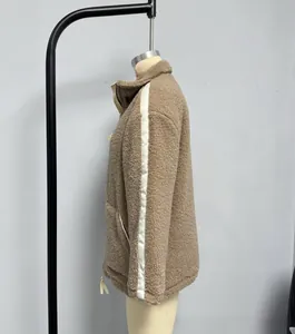 Detail view of camel fleece jacket featuring side white stripes and metal zipper on hem
