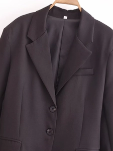 Detail of classic black notched lapel and button closure on women's tailored blazer