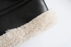 Close-up of black lychee leather jacket with thick white shearling lining and stitching