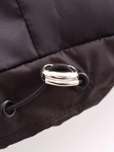 Detail of silver metal adjuster with black elastic drawstring on nylon vest fabric