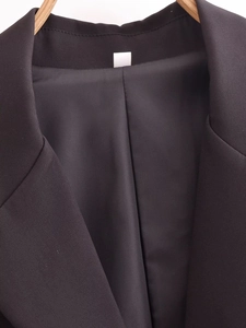 Detailed close-up of smooth inner lining and notch lapel of a black tailored blazer