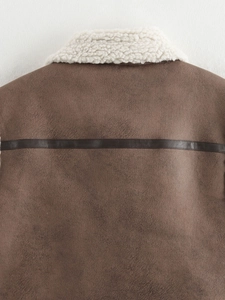 Close-up of brown suede vest back with shearling trim and dark leather strap detail