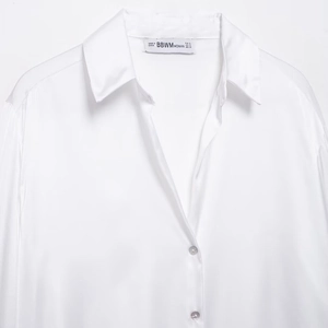 Chemise élégante en satin blanc à manches longues avec texture brillante et col classique