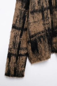 Close-up of thick plaid knit fabric texture in brown and black with soft fuzzy mohair finish