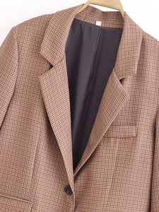 Detail of notched lapel and brown houndstooth pattern on a stylish blazer jacket