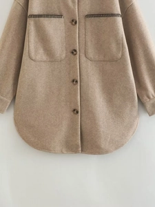 Close-up of contrast stitching detail and tortoiseshell buttons on wool blend shacket