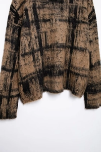 Close-up detail of soft mohair knit sweater with brown and black plaid pattern