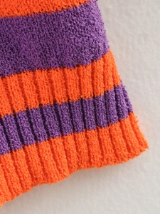 Macro shot of orange and purple striped knit fabric with detailed rib-knit cuff texture