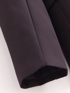 Detailed view of the dark brown blazer cuff showing premium fabric texture and stitching