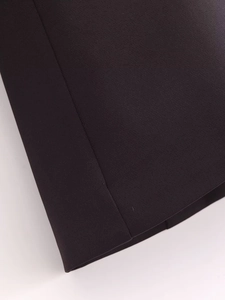 Detailed close-up of dark woven fabric showing fine texture and professional stitching seams