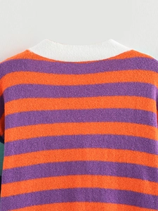 Close-up of vibrant orange and purple striped knit texture with white V-neck stitching