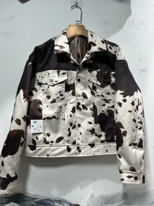 Gros plan de la veste à imprimé vache noir et blanc avec boutons métalliques