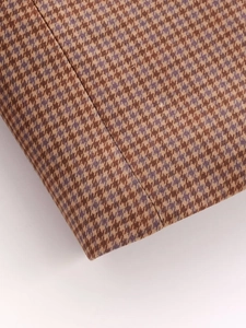 Detailed macro view of houndstooth wool blend fabric and professional stitching line