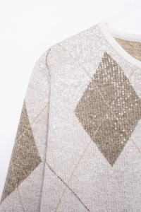 Détail du cardigan en maille losanges avec paillettes brillantes et tissu doux
