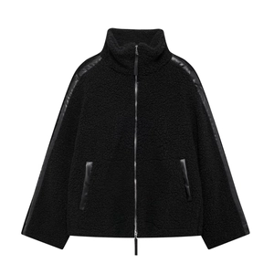 Detail of black sherpa fleece jacket featuring faux leather paneling and silver zipper