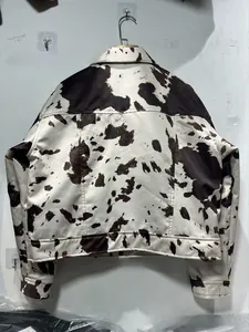 Vue détaillée du dos d'une veste à imprimé vache noir et blanc avec ourlet soigné
