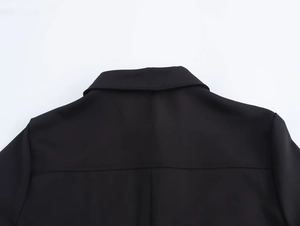 Dettaglio del colletto posteriore e delle cuciture sulle spalle di un abito midi nero