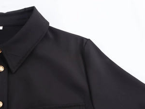Dettaglio del colletto classico della camicia nera a maniche lunghe con eleganti bottoni d'oro