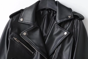 Detail of black faux leather motorcycle jacket collar with silver metal snap buttons